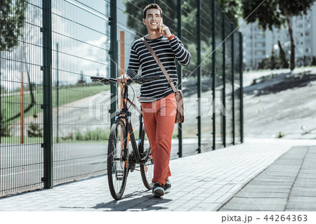 Cheerful positive guy approaching destination on bicycle 44264363