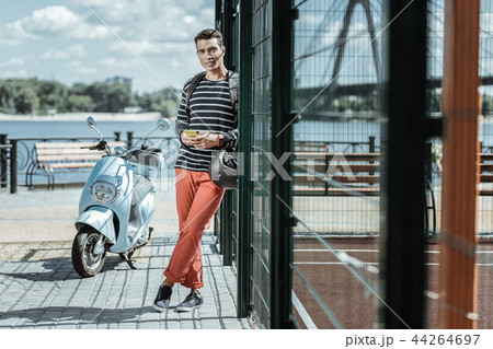 Adorable attractive guy waiting for friends near motorbike 44264697