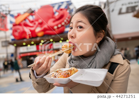 woman is using chopsticks eating takoyaki woman is using chopsticks eating takoyaki 44271251
