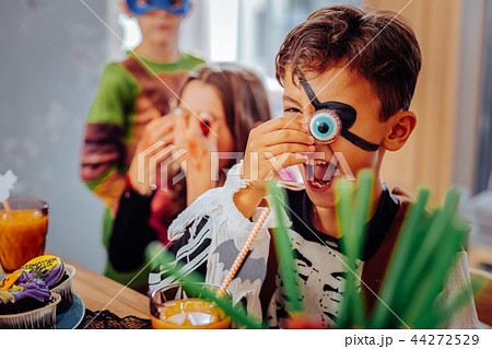 Handsome cute dark-haired boy feeling happy celebrating Halloween with friends 44272529