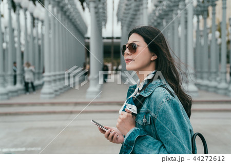 lady holding her cellphone walking by the LACMA lady holding her cellphone walking by the LACMA 44272612