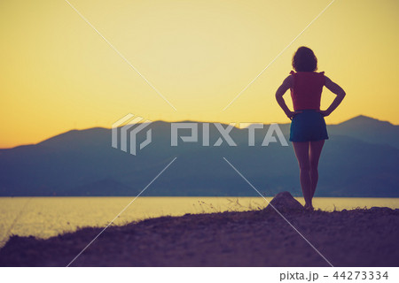 Woman relaxing on coastline Woman relaxing on coastline 44273334