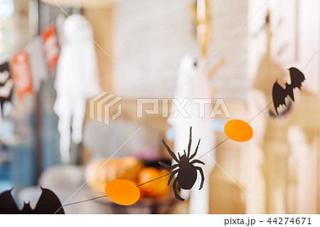 Cute little paper spiders hanging above the table as decorations for Halloween Cute little paper spiders hanging above the table as decorations for Halloween 44274671