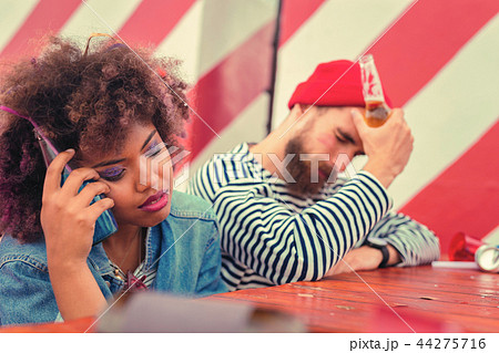 Two people pressing cold bottles to their heads and feeling bad 44275716