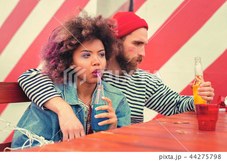 Serious couple frowning and holding drinks after the party Serious couple frowning and holding drinks after the party 44275798