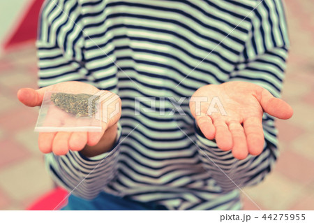Hand with tobacco package placed next to the hand without it 44275955
