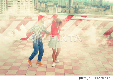 Beautiful couple smiling and dancing in white smoke Beautiful couple smiling and dancing in white smoke 44276737