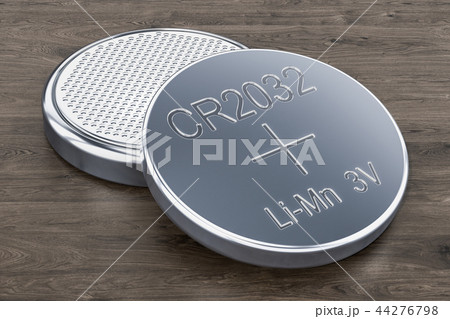 Two button cells on the wooden table, 3D rendering 44276798