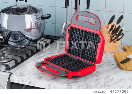 Opened waffle iron closeup on the kitchen table Opened waffle iron closeup on the kitchen table 44277095