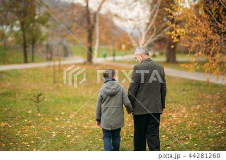 Back view of grandpa and grandson in park. Childhood. autumn Back view of grandpa and grandson in park. Childhood. autumn 44281260