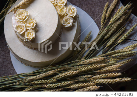 Wedding cream cake on rustic background. Beautiful Gourmet tart decorated with white roses and ears 44281592
