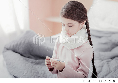 Close up of small girl holding thermometer 44283536