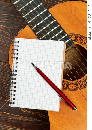 Guitar with blank notebook and pen. 44284119