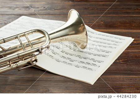 Trumpet and musical notes on wooden background. 44284230