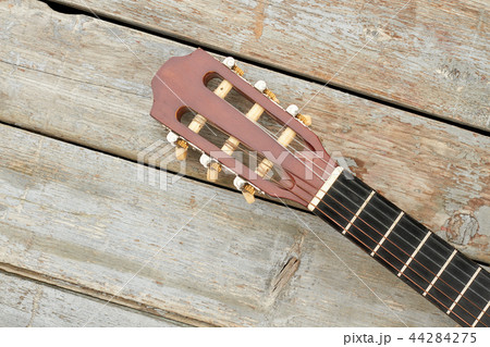 Head of acoustic guitar on wooden background. Head of acoustic guitar on wooden background. 44284275