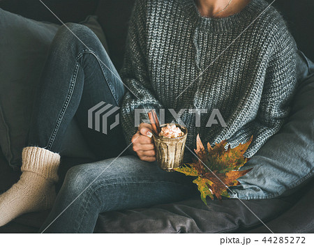 Woman in woolen sweater holding mug with hot chocolate Woman in woolen sweater holding mug with hot chocolate 44285272