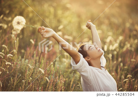 Beautiful carefree woman in fields being happy outdoors 44285504