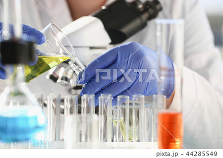 A male chemist holds test tube of glass in his hand A male chemist holds test tube of glass in his hand 44285549