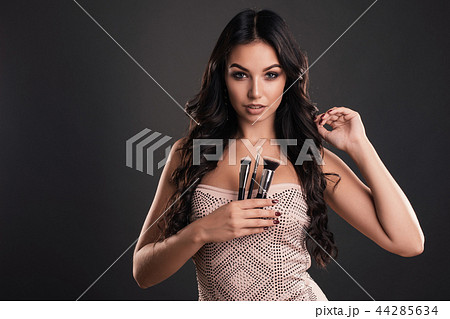 Portrait of beautiful woman with makeup brushes 44285634