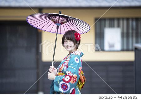 京都府京都市東山区祇園町の花見小路を和傘をさして散策している笑顔の着物姿の若い女性 44286885