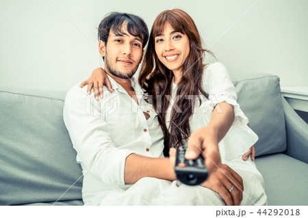 Happy young couple watching TV in living room. Happy young couple watching TV in living room. 44292018