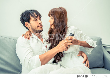 Couple fight fot TV remote in living room. Couple fight fot TV remote in living room. 44292020