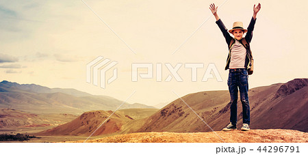 Happy boy traveler with his hands up on mountain 44296791