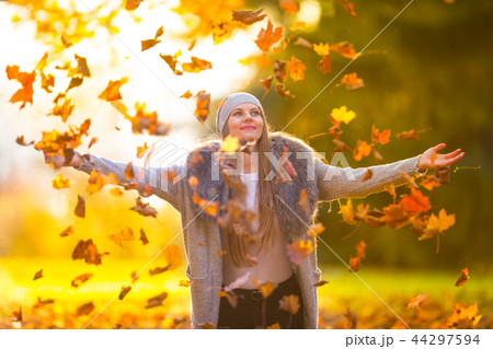Beautiful young woman playing with autumn leaves. Beautiful young woman playing with autumn leaves. 44297594