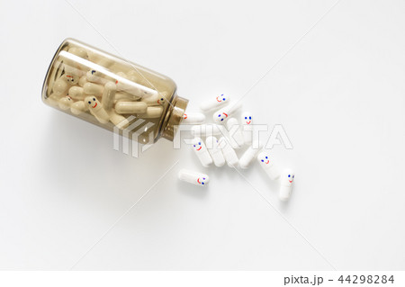 Glass bottle with fun painted emotions on the capsules. View from above. 44298284