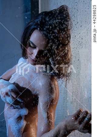 Naked girl in white foam in shower profile shot Naked girl in white foam in shower profile shot 44298625