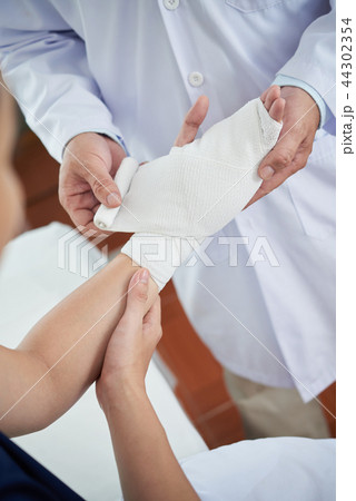 Applying clean bandage Applying clean bandage 44302354
