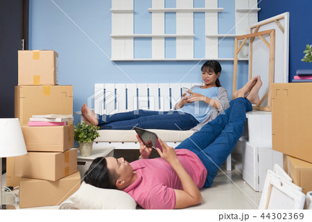 Couple resting after moving in new apartment Couple resting after moving in new apartment 44302369