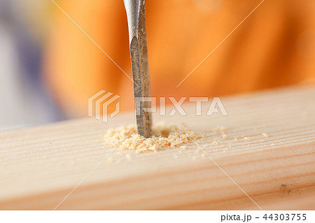 Flat drill bit make hole in wooden bar closeup Flat drill bit make hole in wooden bar closeup 44303755