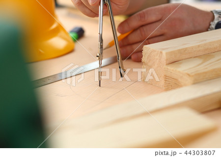 Arms of worker making structure plan on scaled paper Arms of worker making structure plan on scaled paper 44303807