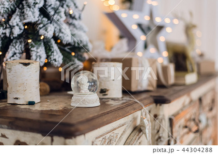 Magical Christmas snow globe with little angel statue inside. Christmas decoration around. Shallow 44304288