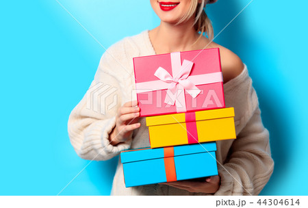 girl in white sweater with gift colored boxes girl in white sweater with gift colored boxes 44304614