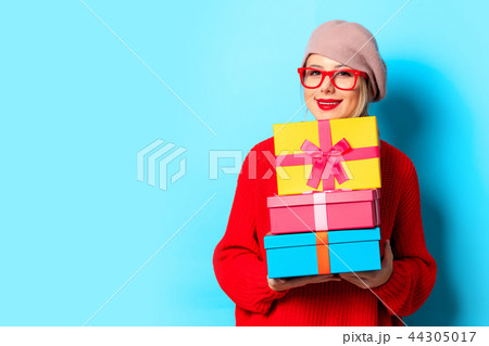 young girl in red sweater with gift boxes 44305017