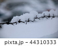 barbed wire fence on winter time backgruond white snow 44310333