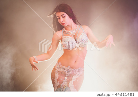 adorable sexy traditional oriental belly dancer girl dancing on luminous smoke background. Woman in adorable sexy traditional oriental belly dancer girl dancing on luminous smoke background. Woman in 44311481