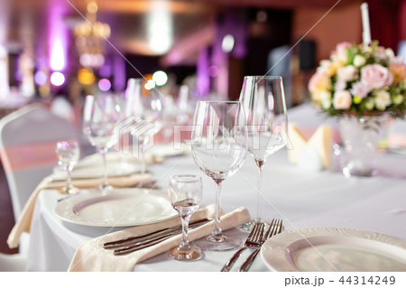 Round table at a luxury wedding reception. Beautiful flowers on the table. Serving dishes, glass 44314249