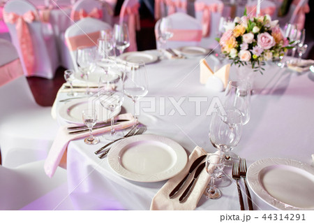 Round table at a luxury wedding reception. Beautiful flowers on the table. Serving dishes, glass 44314291