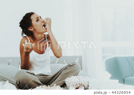 Lonely Crying Woman Is Eating Popcorn On The Bed. Lonely Crying Woman Is Eating Popcorn On The Bed. 44326954