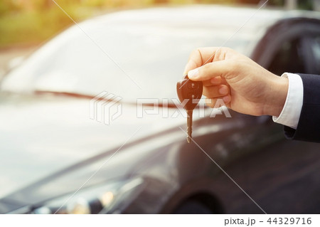 Man is holding car keys with car Man is holding car keys with car 44329716
