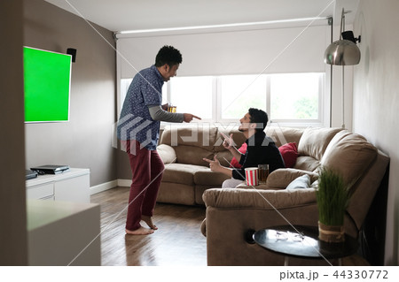 Happy Gay Couple Watching Sports Game On TV At Home Happy Gay Couple Watching Sports Game On TV At Home 44330772