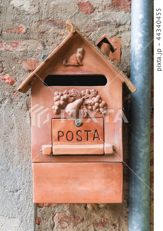 Old clay mailbox in Italian town. Orange mailbox. Old clay mailbox in Italian town. Orange mailbox. 44340455