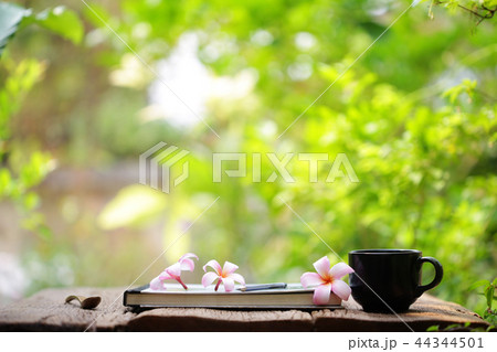 Black coffee cup and notebook on wooden table Black coffee cup and notebook on wooden table 44344501