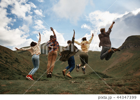 Full length of excited people jumping in the mountains 44347399
