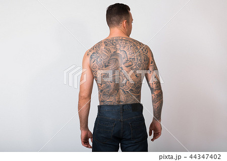 Portrait Of Shirtless Man With Tattoos Against White Background 44347402