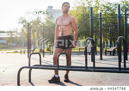 Fitnes man posing on street fitness station showing his muscular body Full lenght portrait. Fitnes man posing on street fitness station showing his muscular body Full lenght portrait. 44347788