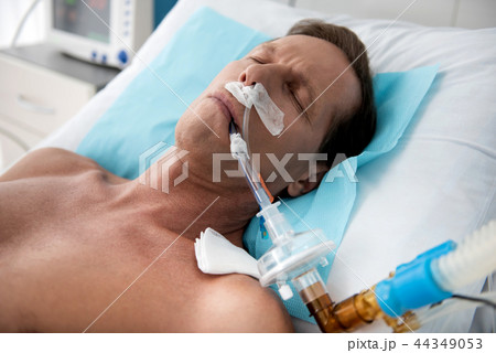 Patient on mechanical ventilation lying in intensive care ward 44349053